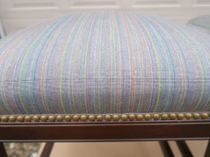 Kitchen Island Stool | Detailed with Decorative Brass Nail Trim and Pattern Matched Boxing | Upholstered in Sunbrella Escapade-Electro | Upholstered by Cape Cod Upholstery Shop | Located in South Dennis, MA