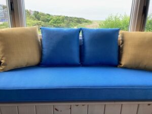 85" window seat with four 18" square throw pillows | Cushion covers upholstered with JF & Greenhouse Fabrics | Upholstered by Cape Cod Upholstery Shop | Located in South Dennis, MA 02660