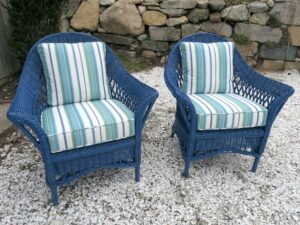 Matching wicker chairs, painted blue as part of a three piece set. Cushion covers upholstered in a Perennials Beachcomber Stripe outdoor fabric. All new antimicrobial seat foam wrapped in dacron batting. All new weatherproof back pillow inserts. Upholstered by Cape Cod Upholstery Shop | Located in South Dennis, MA 02660