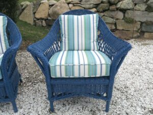One of two wicker chairs, painted blue as part of a three piece set. Cushion covers upholstered in a Perennials Beachcomber Stripe outdoor fabric. All new antimicrobial seat foam wrapped in dacron batting. All new weatherproof back pillow inserts. Upholstered by Cape Cod Upholstery Shop | Located in South Dennis, MA 02660