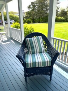 Blue Wicker chair on a covered porch | Cushion covers fabricated in a Perennials stripe indoor-outdoor fabric | Cushion inserts are rated for outdoor use | Cushions fabricated by Cape Cod Upholstery Shop | Located in South Dennis, MA 02660