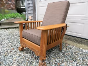Lions foot oak Morris Chair with a side view | Loose seat and back cushion covers upholstered in a Sunbrella Dupione chestnut brown fabric | Morris Chair frame refinished by Wesley Woodworking in Orleans, MA | Cushion Covers upholstered by Cape Cod Upholstery Shop | Located in South Dennis, MA 02660