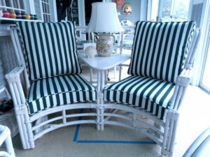 Vintage curved Rattan Settee with two separate chairs attached in the middle by a table | Cushion covers upholstered with Sunbrella Mason Forest Green stripe and outdoor rated cushion inserts | Upholstered by Cape Cod Upholstery Shop | Located in South Dennis, MA 02660
