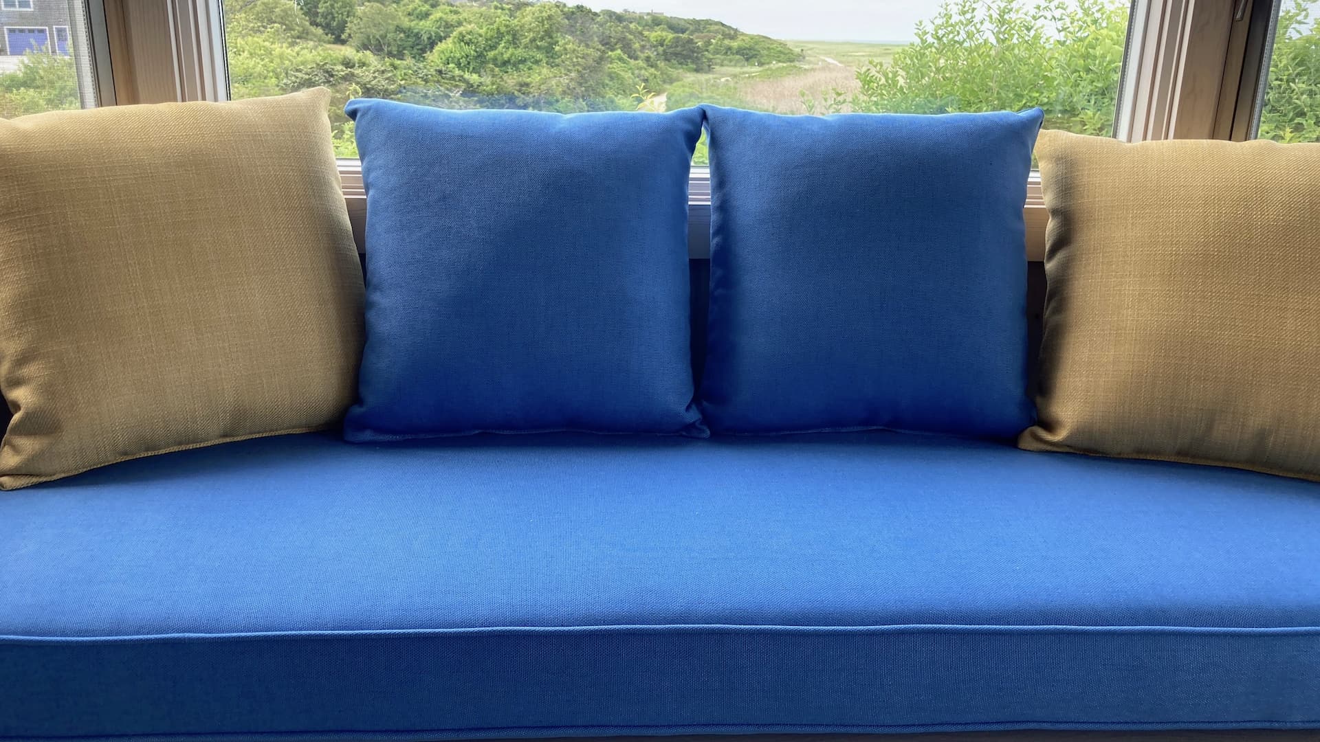 85" window seat with four 18" square throw pillows | Cushion covers upholstered with JF & Greenhouse Fabrics | Upholstered by Cape Cod Upholstery Shop | Located in South Dennis, MA 02660