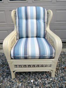 Cream Colored Rattan chair with loose seat and back cushions | Upholstered in a Sunbrella Scope Cape stripe fabric | Upholstered by Cape Cod Upholstery Shop | Located in South Dennis, MA 02660