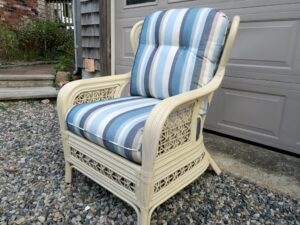 Cream Colored Rattan chair with loose seat and back cushions | Upholstered in a Sunbrella Scope Cape stripe fabric | Upholstered by Cape Cod Upholstery Shop | Located in South Dennis, MA 02660