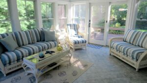 Rattan sofa, love seat and chair shown in the clients three season room. Upholstered in a Sunbrella Scope Cape stripe fabric | Upholstered by Cape Cod Upholstery Shop | Located in South Dennis, MA 02660