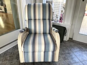 Rattan recliner shown in the clients three season room. Upholstered in a Sunbrella Scope Cape stripe fabric | Upholstered by Cape Cod Upholstery Shop | Located in South Dennis, MA 02660