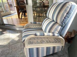 Rattan swivel recliner shown in the clients three season room. Upholstered in a Sunbrella Scope Cape stripe fabric | Upholstered by Cape Cod Upholstery Shop | Located in South Dennis, MA 02660