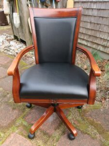 Office chair with a swivel base. Upholstered in a Greenhouse Fabrics black vinyl material. Upholstered by Cape Cod Upholstery Shop | Located in South Dennis, MA 02660