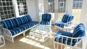 Rattan chairs and sofa. Sunbrella Milano Cobalt. Three season room with white rattan chairs and sofa. Cushions fabricated with Sunbrella Milano Cobalt. All new CertiPur-US upholstery foam. Cushions fabricated by Cape Cod Upholstery Shop - South Dennis, MA 02660