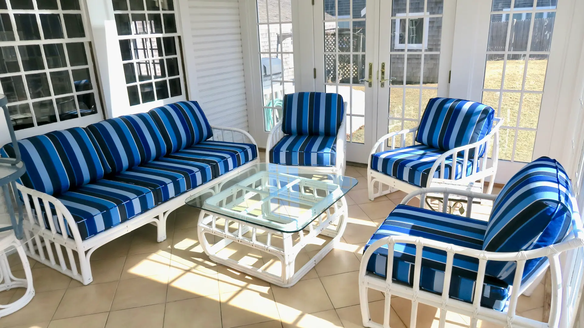 Three season room with white rattan chairs and sofa. Cushions fabricated with Sunbrella Milano Cobalt. All new CertiPur-US upholstery foam. Cushions fabricated by Cape Cod Upholstery Shop - South Dennis, MA 02660